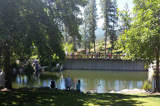 Visitors relaxing by the pond at Falls Park in Post Falls, Idaho